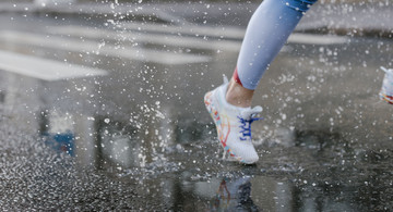 Foto von cottonbro von Pexels: Frau läuft bei Regen Ausschnitt Bein
