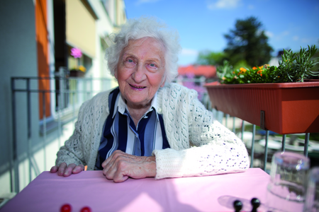 Seniorin sitzt auf Balkon