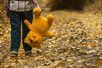 Kind mit Teddy in der Hand im Freien
