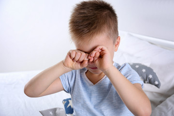 Kugelzellanämie: Junge sitzt müde auf seinem Bett