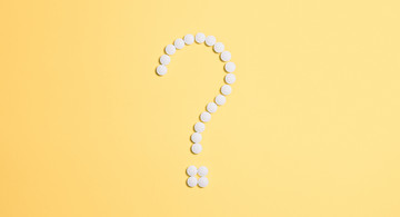 Foto von Anna Shvets von Pexels (Weiße Tabletten als Fragezeichen; Hintergrund gelb)