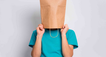 Person hat Papiertüte über dem kopf