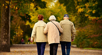 Drei Senioren gehen im Park spazieren