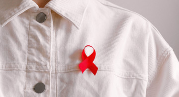 Rote Schleife für Aids an weißer Jeansjacke
